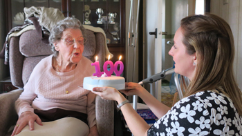 Centenarian Mabel Poultney blows out the candles on her 100th birthday cake.